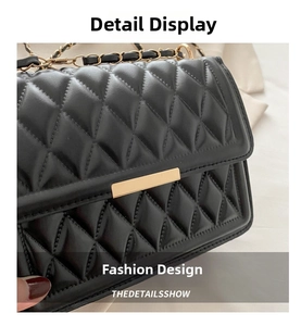 Close-up of black quilted leather texture and gold metal clasp on a small square bag