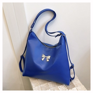 Dettaglio borsa tote blu in pelle PU con fibbia a fiocco argento e tracolla