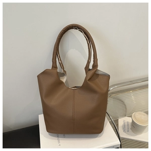 Close-up of brown lychee texture leather tote bag with sturdy double handles and stitching