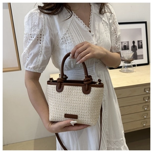 Détail du sac à main en paille tissée avec garniture en cuir brun et poignées rondes