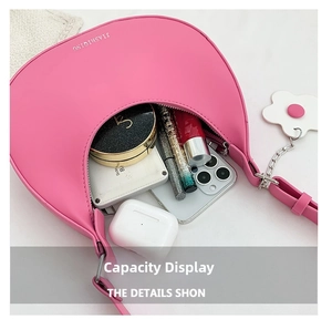 Pink crescent underarm bag showing interior capacity with phone and cosmetics