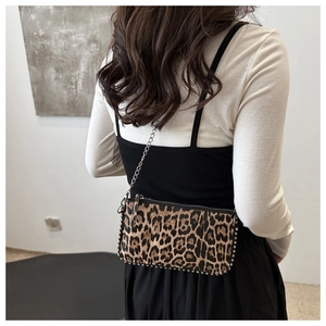 Fashionable leopard print shoulder bag with silver studs and metal chain strap on model