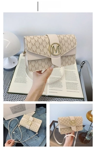 Detail of off-white jacquard crossbody bag with M pattern and golden buckle