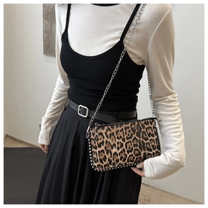 Detail of leopard print crossbody bag with silver bead trim and delicate chain strap