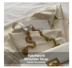 Detail of white leather shoulder bag with gold chain strap on a beige blazer
