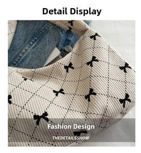 Detail of corduroy tote bag with black bow patterns and diamond quilted texture