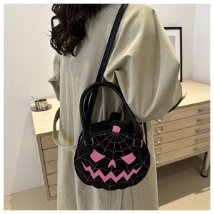 Detail of Halloween pumpkin shaped black leather handbag with pink spider web embroidery