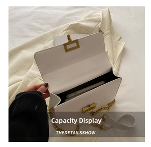 Capacity display of white leather chain bag showing a smartphone stored inside the main pouch