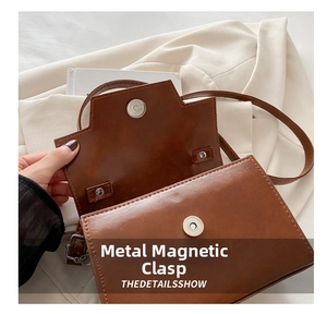 Dettaglio della fibbia magnetica di qualità su una borsa a tracolla quadrata marrone