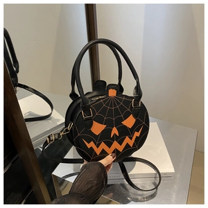 Detail of pumpkin-shaped Halloween handbag with black leather and orange spider web design