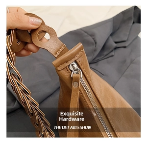 Detail of brown litchi pattern leather tote with silver zipper and knotted strap