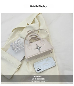 Detail view of cream mini handbag with star metal accent and smartphone for scale