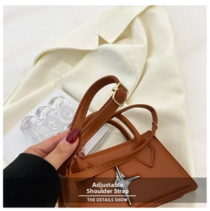 Detail view of the brown leather shoulder bag featuring an adjustable shoulder strap