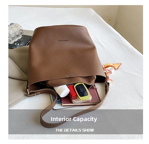 Detail view of large brown bucket bag interior showing capacity for cosmetics and notebooks