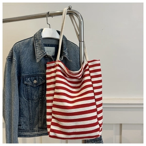 Détail du sac cabas en toile rayé rouge et blanc avec anses en corde et texture en denim