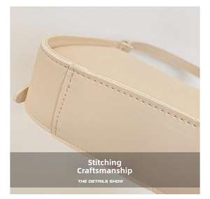 Close-up of precise stitching details and matte leather texture on a beige underarm bag