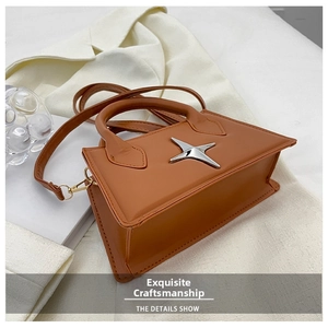 Detail shot of brown trapezoid handbag with silver star metal and adjustable strap
