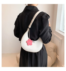 Detail of white half-moon shoulder bag with JIASHIQING logo and pink floral charm