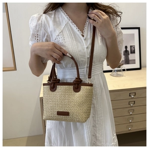 Sac à main en paille tressée pour femme avec bandoulière marron porté par un mannequin