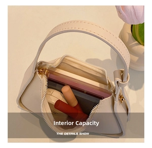 Detail view of the interior capacity showing a mini off-white underarm bag with cosmetics