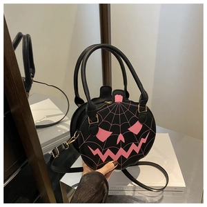 Detail of black pumpkin handbag with pink spiderweb print and golden metal hardware