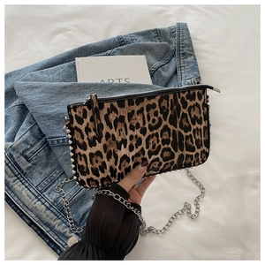 Detailed shot of leopard print handbag with silver chain strap and pearl bead accents