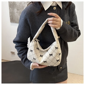Detail view of the crescent pillow bag showing corduroy texture and bow pattern