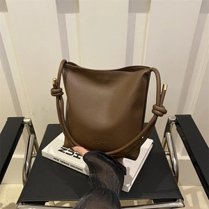 Minimalist brown lychee pattern bucket bag with leather strap and knot detail