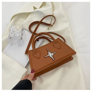Detail of brown square crossbody bag with silver star metal accent on white blazer