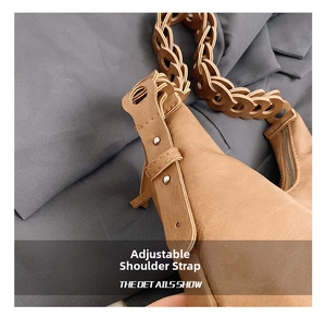 Close-up of adjustable leather shoulder strap with metal studs and woven chain detail