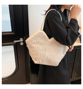 Dettaglio borsa shopper bianca con frange a quadretti e sottili spalline in pelle