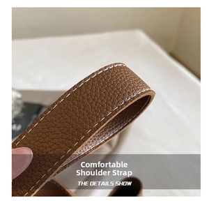 Macro detail of brown lychee grain leather strap with contrast white stitching