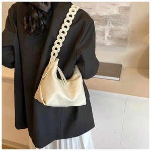 Detail of off-white crescent underarm bag with unique cutout strap and leather texture