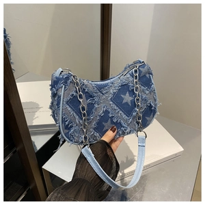 Detail of denim plaid shoulder bag with star pattern, silver chain, and frayed edges