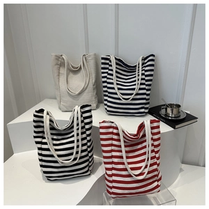 Série de sacs cabas en toile rayée bleue, rouge et noire avec des anses en corde