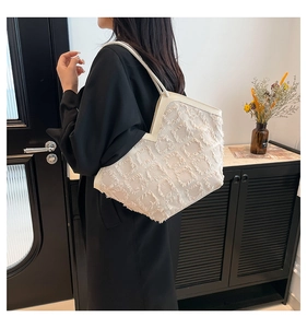 Dettaglio della borsa tote bianca con motivo geometrico a frange e rifiniture in pelle