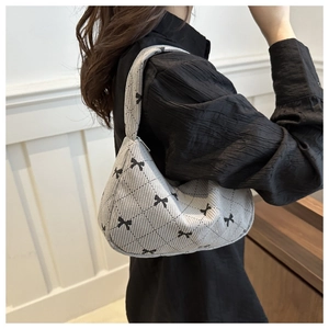 Close-up of light gray corduroy hobo bag featuring black bow and diamond pattern