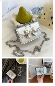 Detail of silver mini crossbody bag with metallic bow and fine chain strap