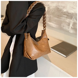 Detail of retro brown leather underarm bag with unique woven shoulder strap design