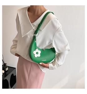 Green crescent hobo bag with adjustable strap and white flower charm detail