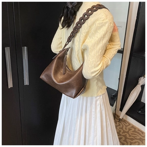 Detail of vintage dark brown leather hobo bag featuring a unique circular chain strap design