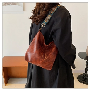 Rear view of brown leather hobo bag with ethnic embroidery wide shoulder strap
