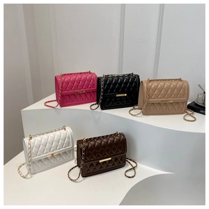 Multiple colors of quilted crossbody bags with gold chain straps on white display steps