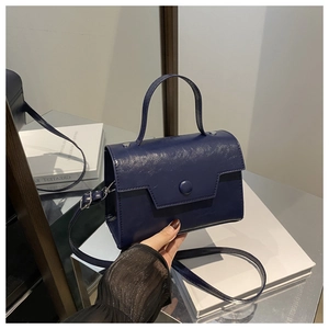 Dettaglio di borsa a mano blu navy in pelle vintage con tracolla e finitura testurizzata