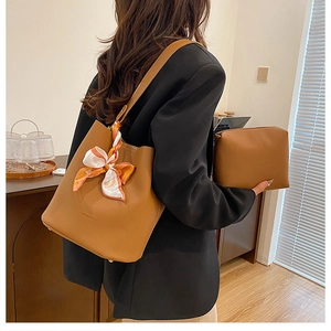 Detail of brown leather bucket bag set with silk scarf and matching small pouch