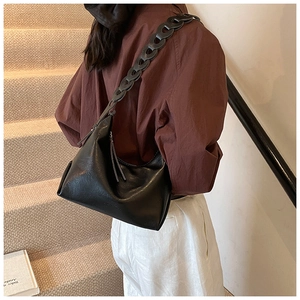 Detail view of the chunky black chain strap and logo embossing on hobo shoulder bag