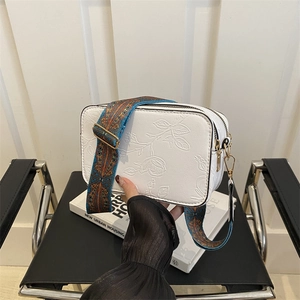 White rectangle crossbody bag with rose floral embossing and colorful wide strap