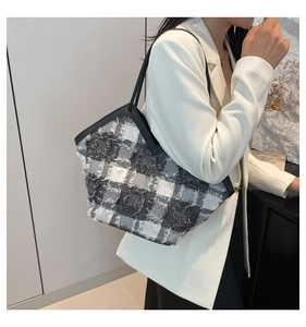 Dettaglio borsa tote in tweed grigio a quadri con frange e bordi in pelle nera