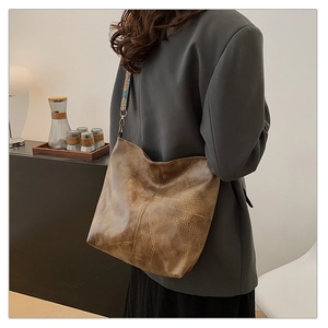 Brown vintage leather tote bag with ethnic geometric wide strap shown on a model