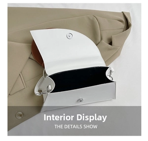 Detail view of white square bag interior with black lining and metal magnetic closure